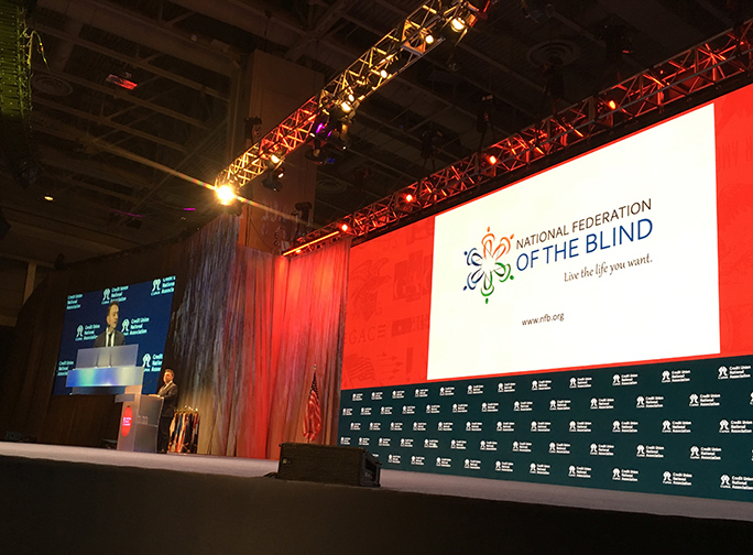President Riccobono stands at the podium on stage at the Walter E. Washington Convention Center.] 